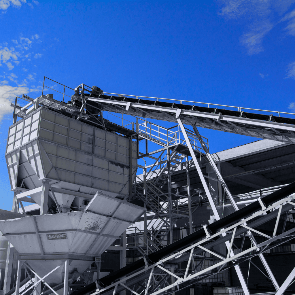 Industrial conveyor system with storage hopper and material handling equipment in plant